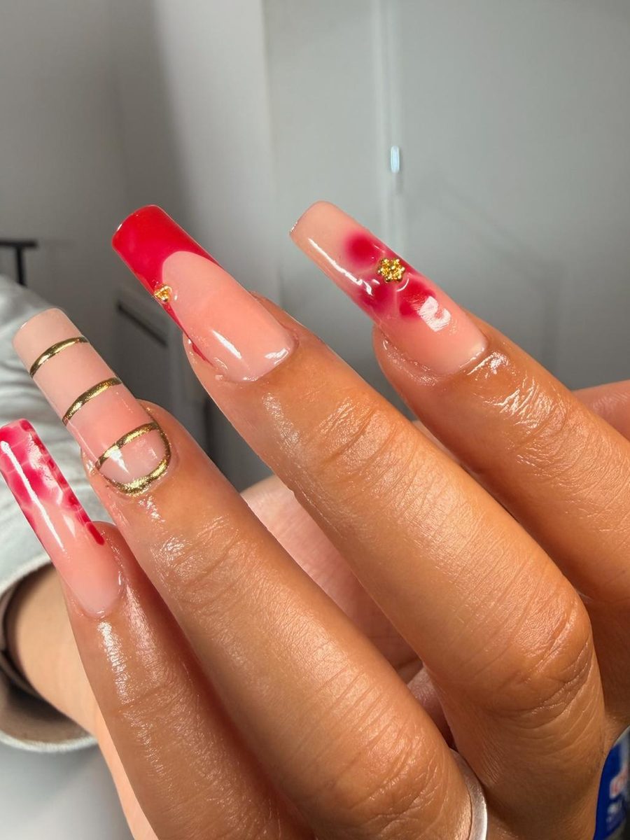 Pose gel longue réalisée par bold.glossy : nude, french rouge, fleurs effet aquarelle et lignes dorées